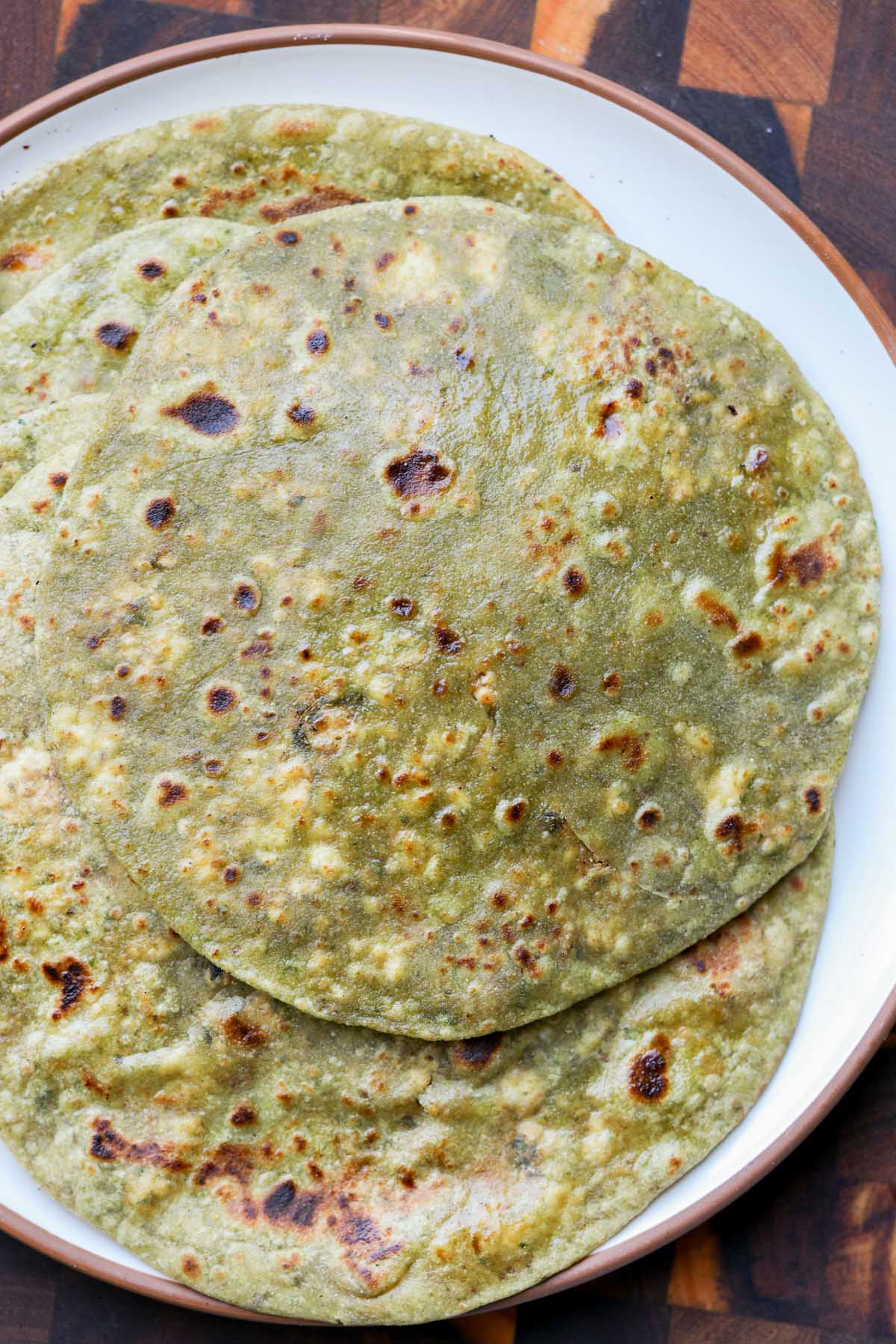 serving plate of spinach parathas