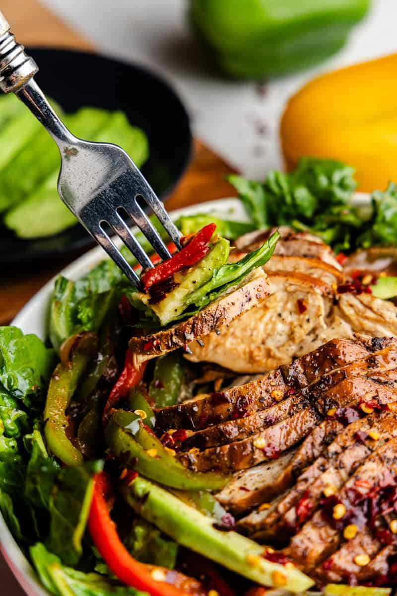 Closeup of Sliced Skinny Chicken Fajita Salad with Fork Bite.