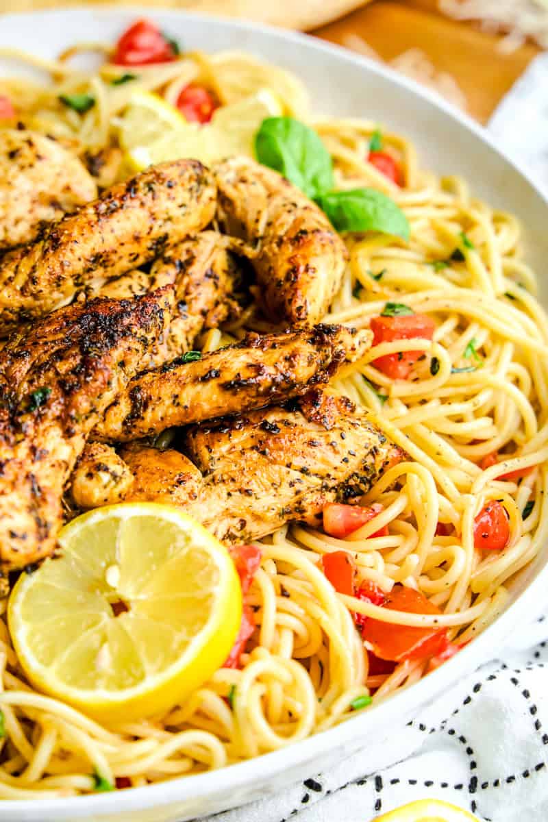 Lemon Herb Chicken Spaghetti in a Large Bowl with Tomatoes and Basil.