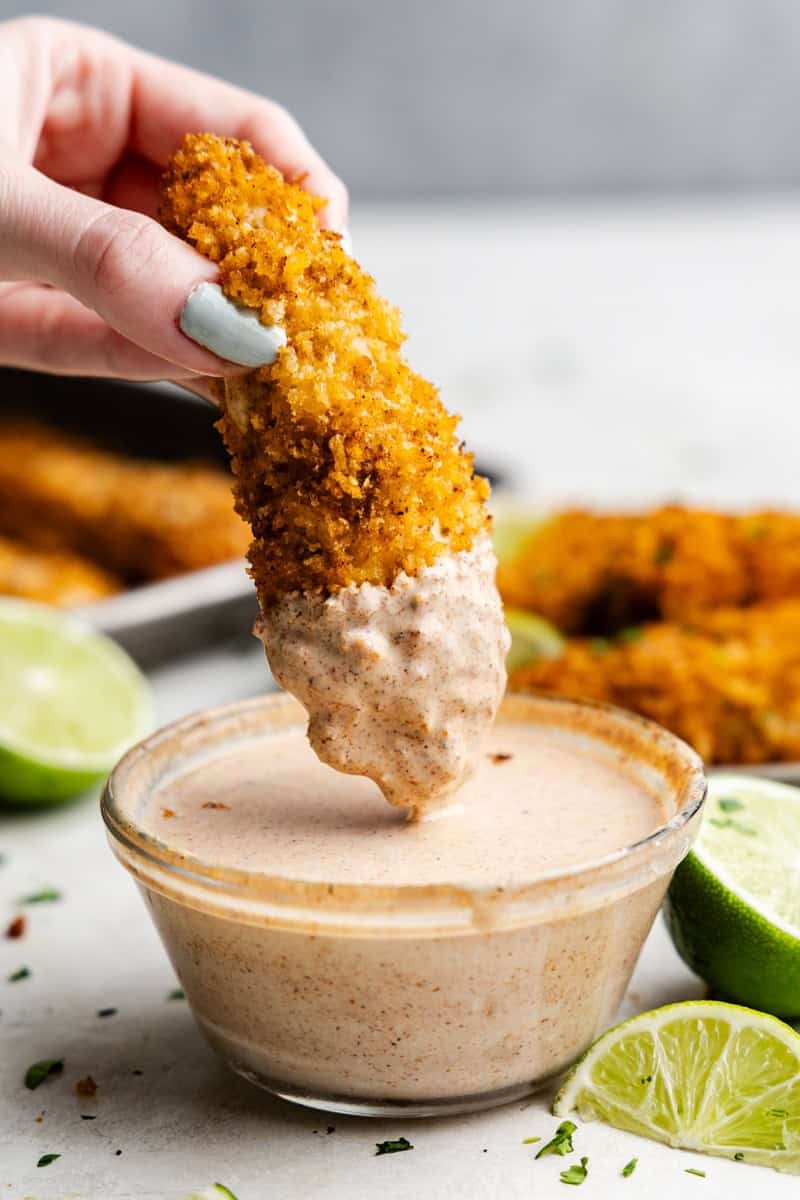 Chile-Lime Baked Chicken Tender Being Dipped into the Sauce.