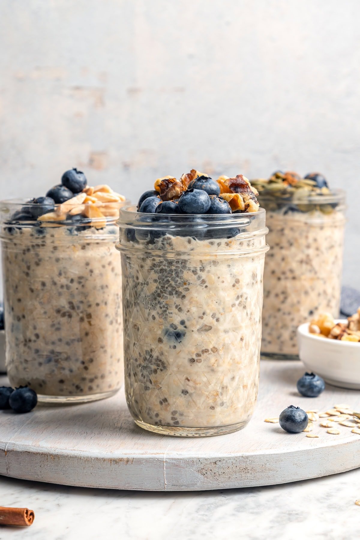 Overnight oats are the easiest way to work a healthy breakfast into your morning! No cooking required, they're a hearty breakfast packed with fiber, vitamins, and nutrients. 3 jars of overnight oats topped with blueberries and walnuts