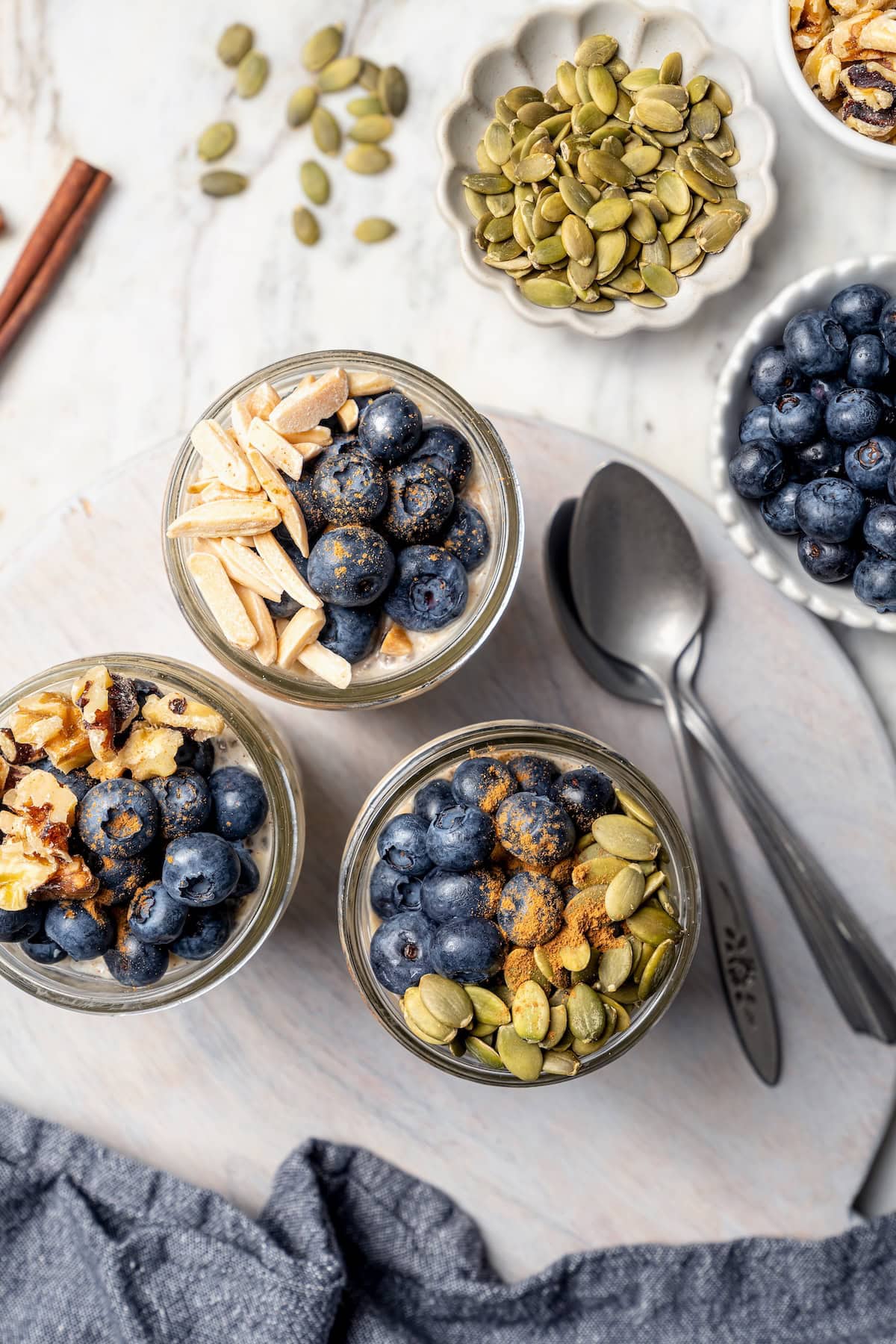 Overnight oats are the easiest way to work a healthy breakfast into your morning! No cooking required, they're a hearty breakfast packed with fiber, vitamins, and nutrients. Overhead view of overnight oats topped with blueberries, nuts, and pepitas