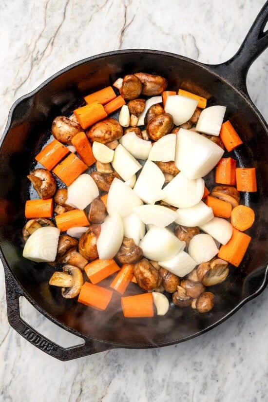 Vegetables in skillet for coq au vin.