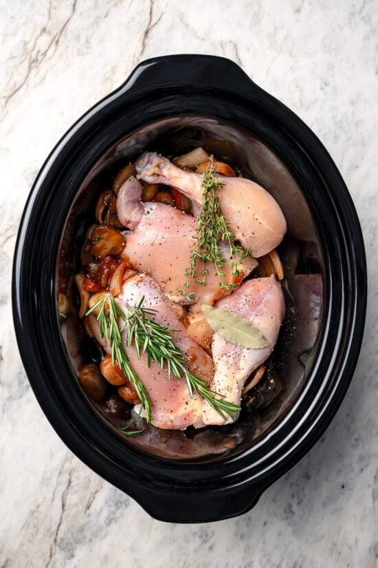 Ingredients added to slow cooker for coq au vin.