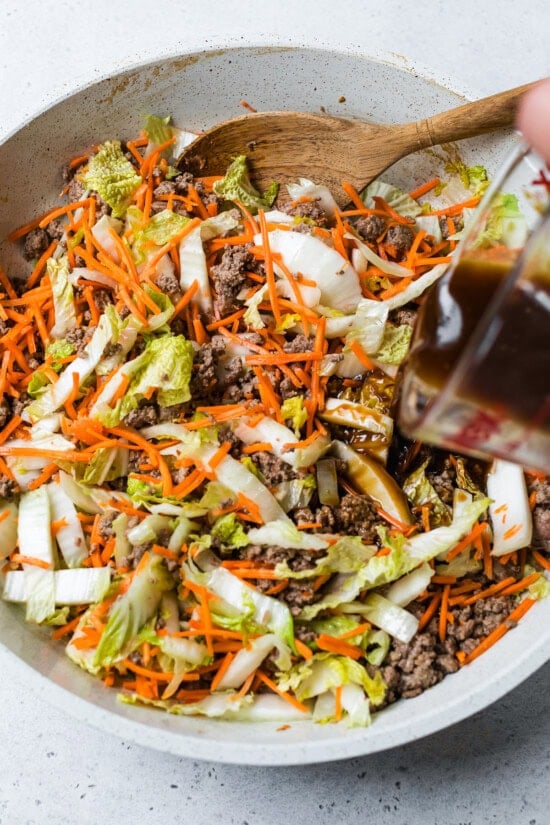 adding stir fry sauce to beef