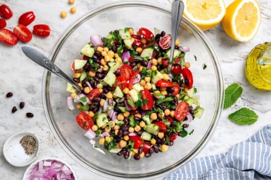 Garbanzo bean Mediterranean salad in glass mixing bowl.