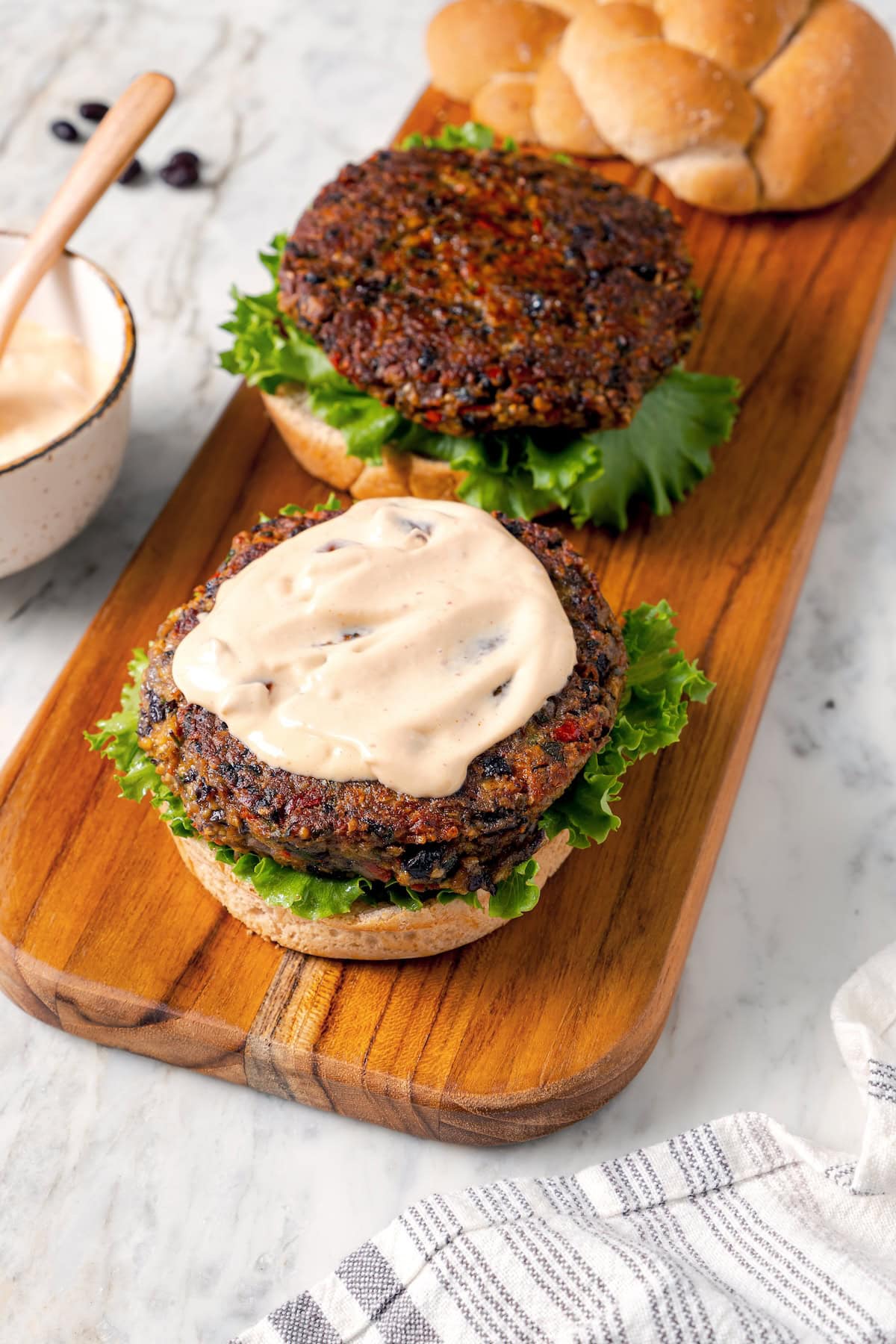 Adding chipotle mayo to homemade black bean burgers.
