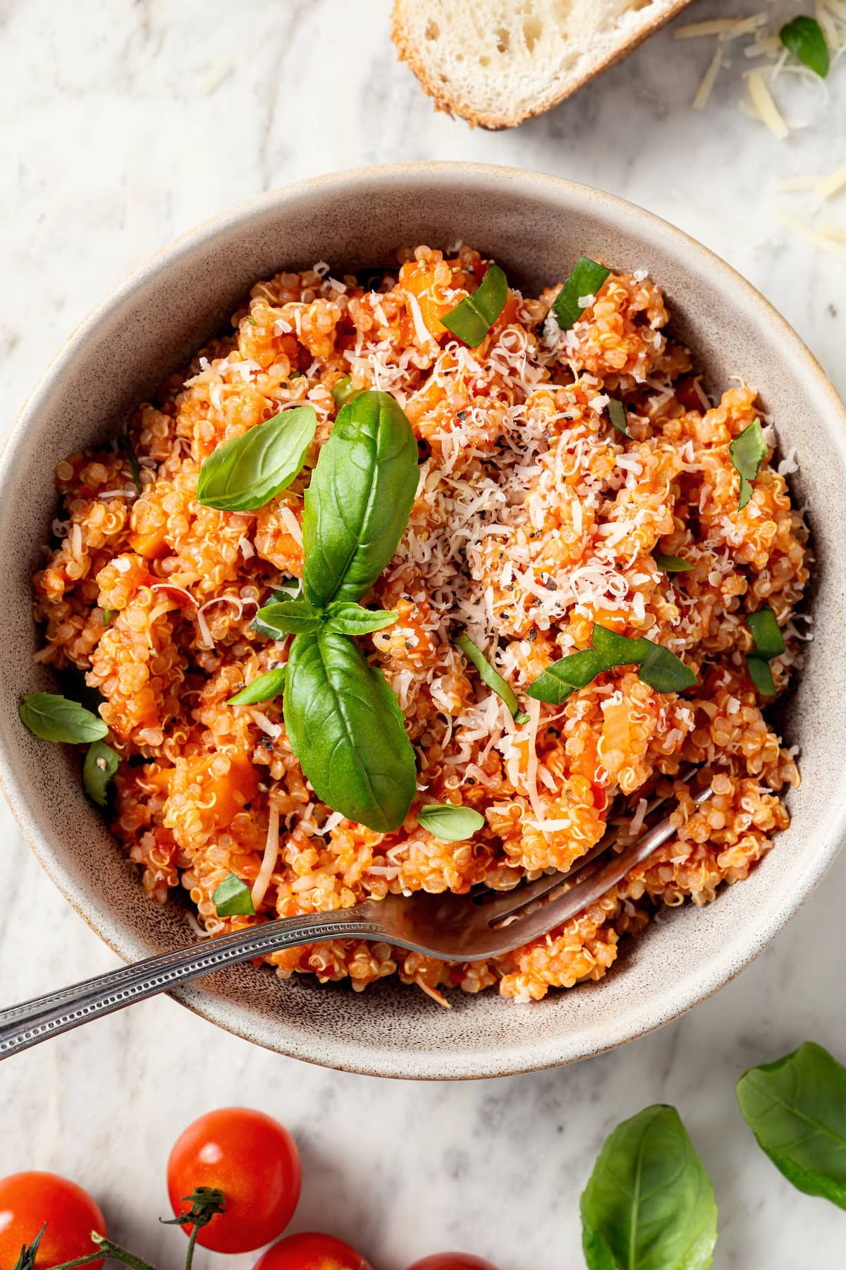 This healthy quinoa risotto swaps out the usual rice for protein-packed cooked quinoa. It's easy, creamy, and ready in just 15 minutes! Bowl of quinoa risotto with fork.