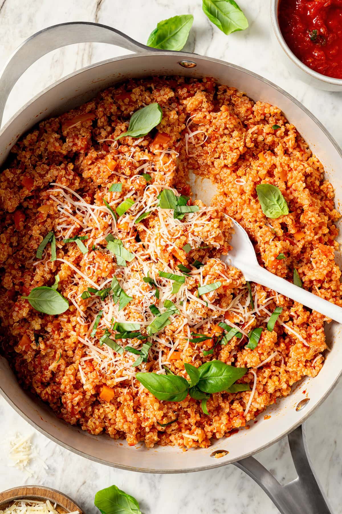 This healthy quinoa risotto swaps out the usual rice for protein-packed cooked quinoa. It's easy, creamy, and ready in just 15 minutes! Skillet of quinoa risotto with serving spoon.