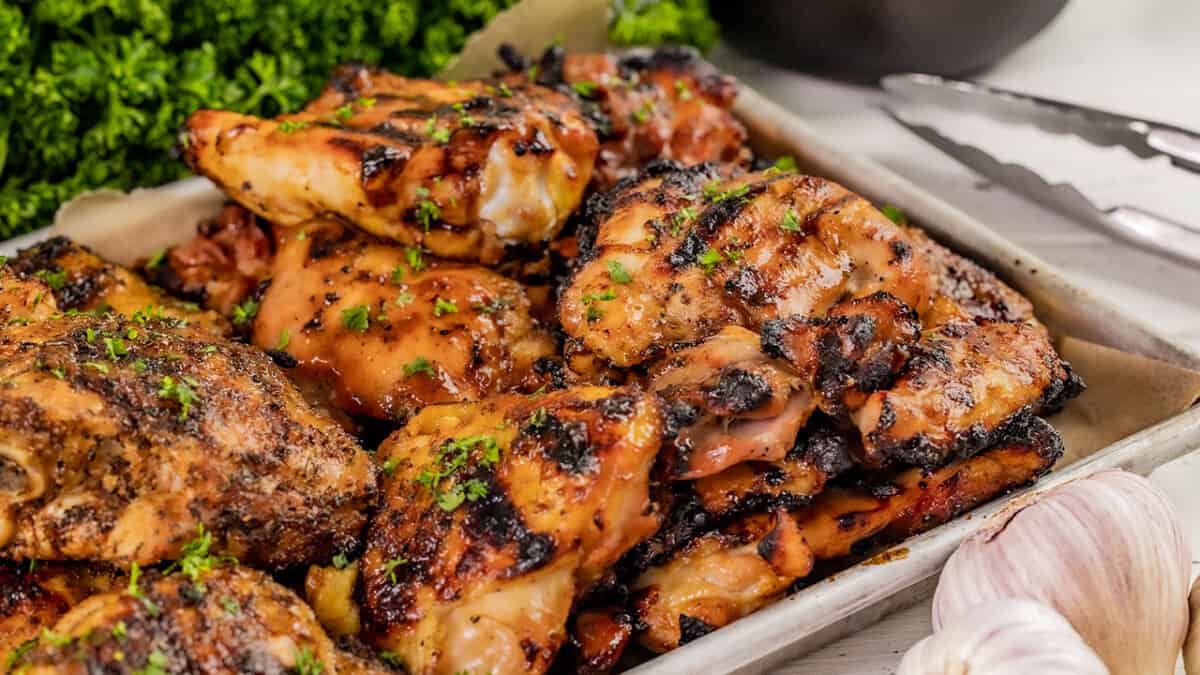 A sheet pan filled with grilled chicken thighs.