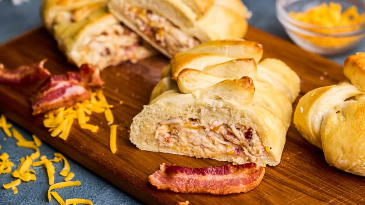 A slice of Chicken Bake (Family Style) with Bacon and cheese on a cutting board.