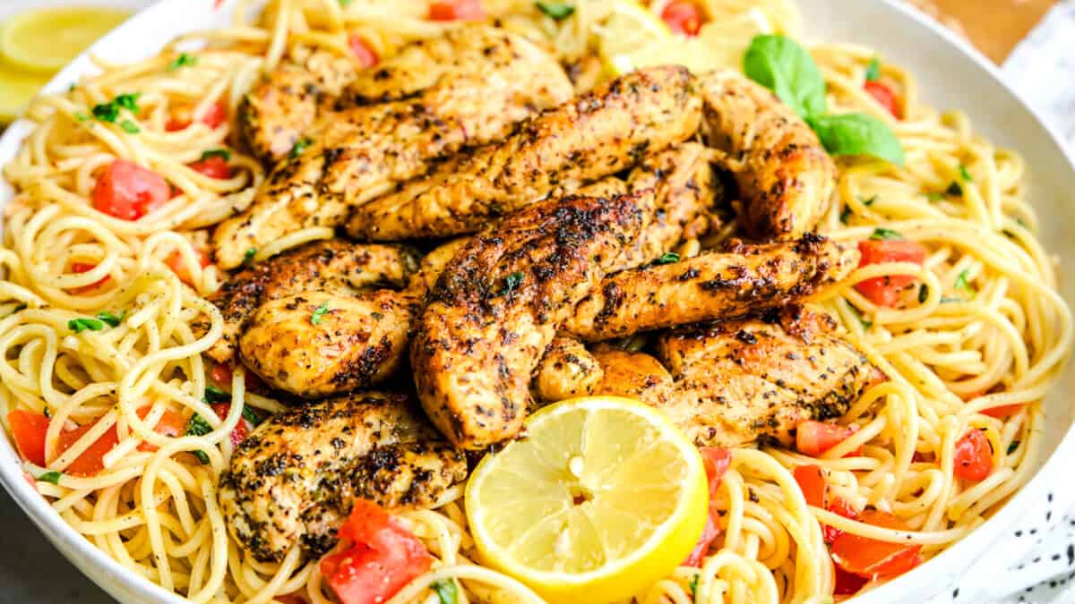 Lemon Herb Chicken Spaghetti in a large bowl with tomatoes and basil.