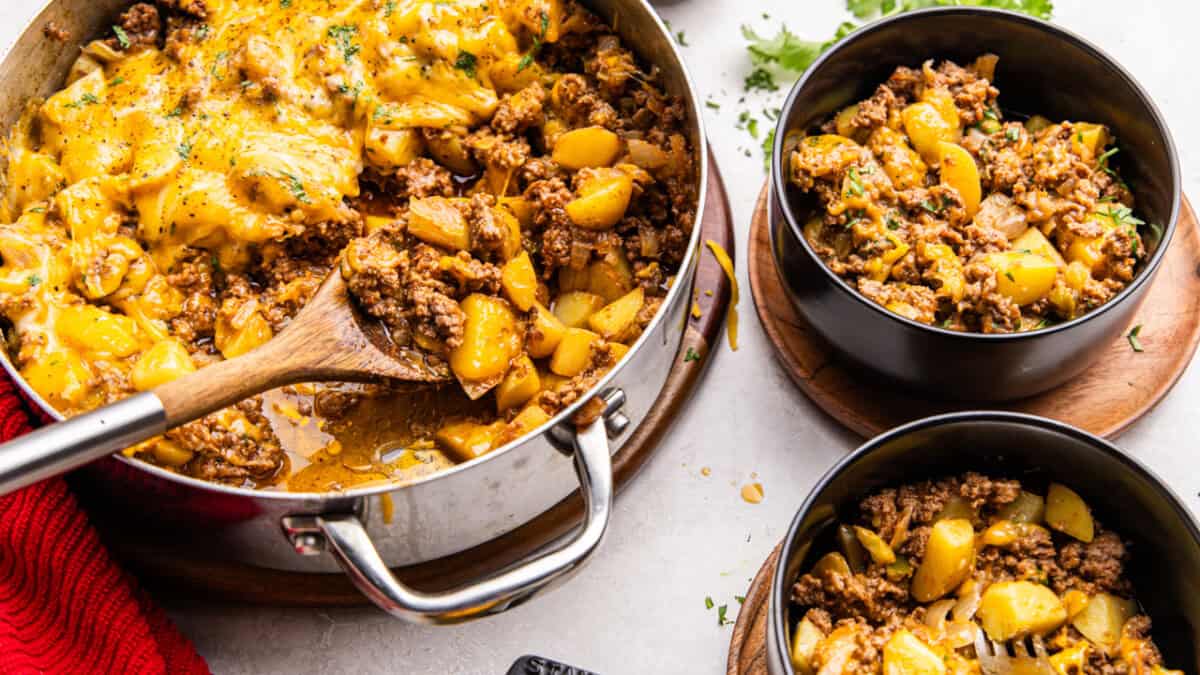 Skillet full of One Pot American Picadillo with two bowls served.