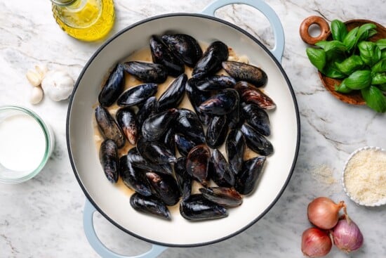 With tender mussels in cream sauce with Parmesan and basil, this recipe is perfect for special occasions, but easy enough for a weeknight! Skillet of mussels.