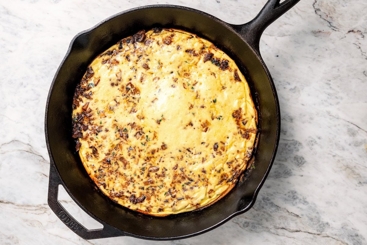 This aromatic mushroom frittata with egg whites, sautéed mushrooms, shallots, and cheese is an easy-to-make gourmet breakfast or brunch. Baked mushroom frittata in a skillet.