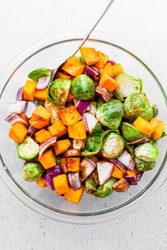 Toss veggies with spices in a bowl