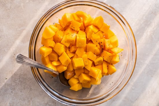 Cubed butternut squash in a glass bowl.