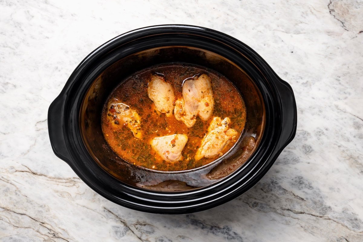 The easiest crockpot salsa chicken with juicy chicken thighs, jarred salsa, and simple spices. Great for meal prep, tacos, and rice bowls! Cooked chicken breasts in salsa mixture inside the crockpot.