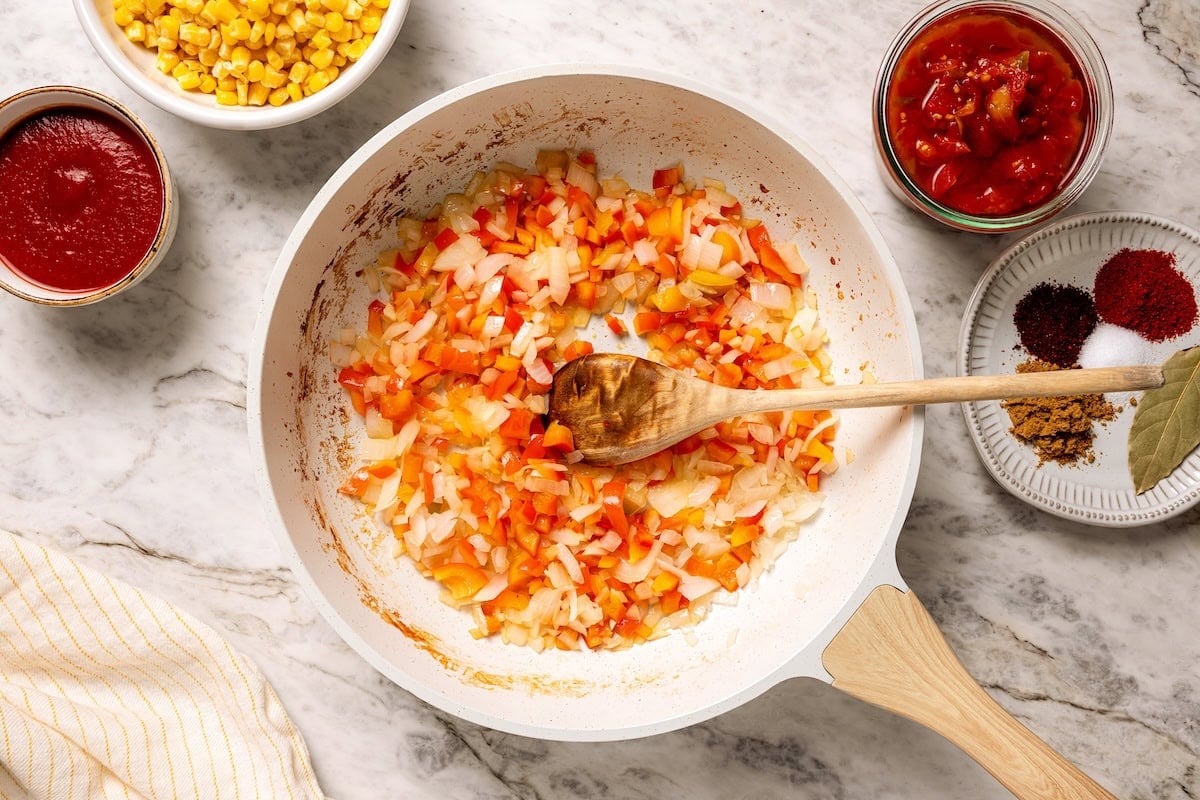 This crock pot turkey chili recipe is easy to make and family-friendly, with ground turkey, corn, bell pepper, tomatoes, and mild spices. Sautéed diced vegetables in a skillet.