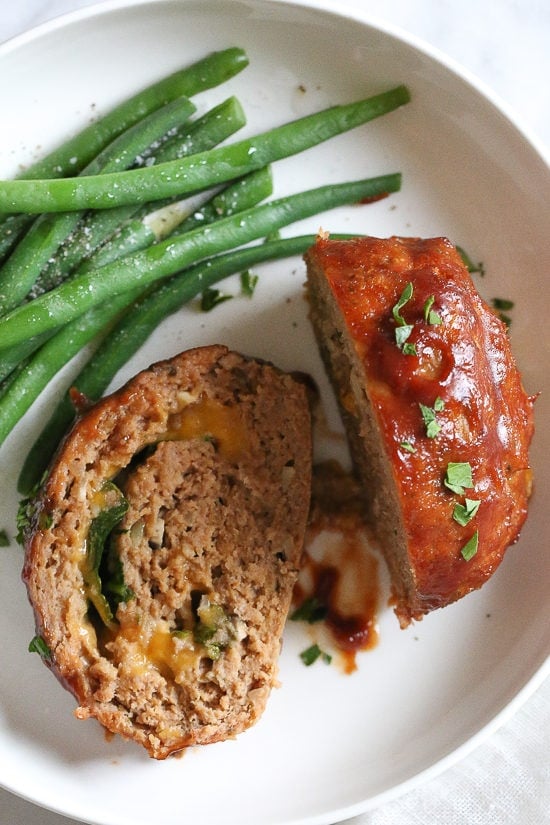 The best tasting, moist turkey meatloaf stuffed with cheddar cheese, spinach and rolled, jelly roll style topped with a ketchup based glaze.